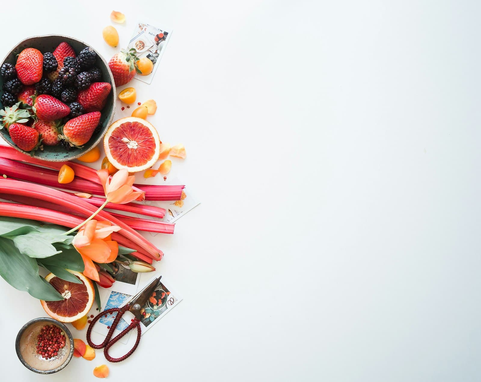 Fresh fruit including berries and citrus arranged on a white countertop